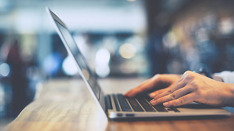 A close view of a person typing on a laptop