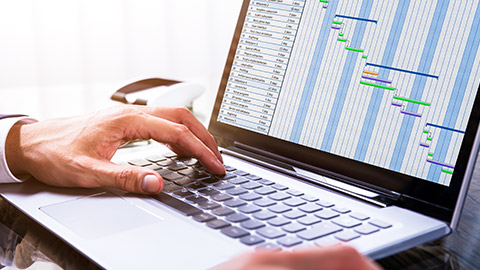 A close view of a person creating a gantt chart on a laptop