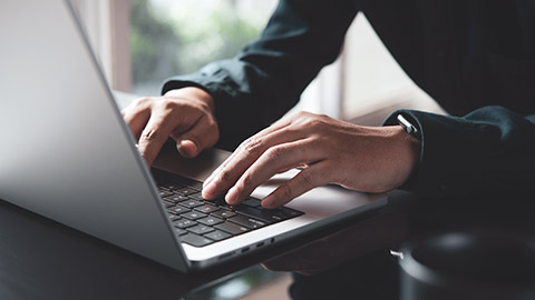 A close view of a person typing on a laptop