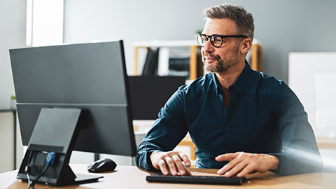 An accountant working on a desktop computer