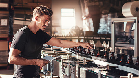 A small business owner looking at his product being manufactured