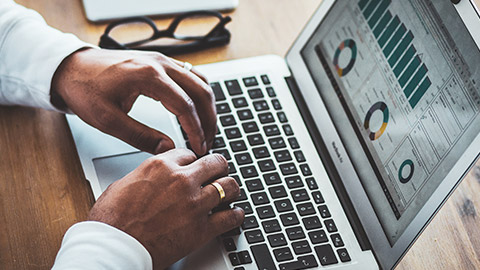 Close view of hands on a keyboard entering financial data