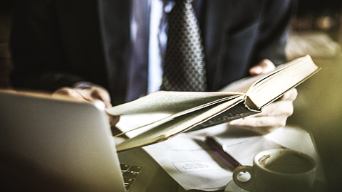 A person going over and reviewing procedures and policies in bookkeeping