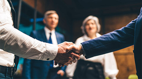 Two business shaking hands, agreeing to terms relating to their operations and finance