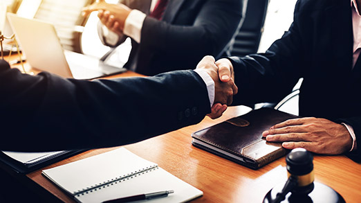 shaking hands to seal a deal with his partner lawyers or attorneys discussing a contract agreement