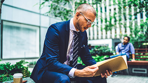 A lawyer seated in a public space, reviewing a client's records