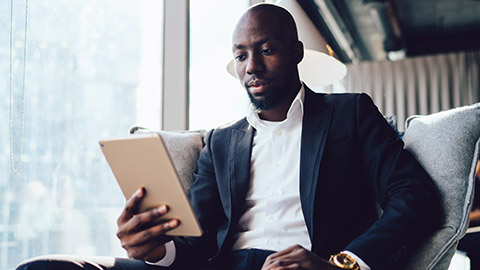 An executive reading business results on a tablet device