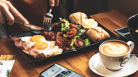 A close view of a person eating a meal at a cafe