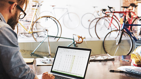 An owner of a bicycle shop doing their end-of-month financial reporting