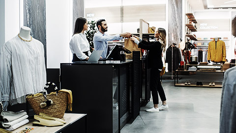 A clothing store's staff servcing a client