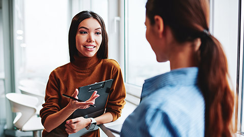 2 business associates talking in an office environment