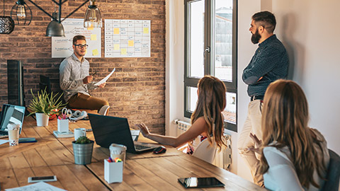 A group of coworkers discussing business in an informal office setting