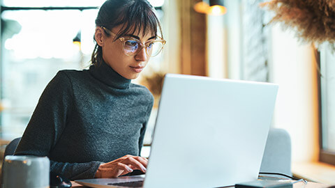 A business professional typing up report information on a laptop