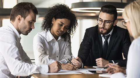 Team of businesspeople gathering ideas and creating a draft of a complex document