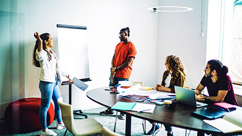 A small team holding an interactive meeting, working through their production targets and timeframes