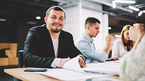 An accountant sitting at a table with fellow employees