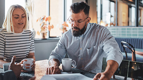 2 colleagues discussing the agenda at a meeting in a casual environment