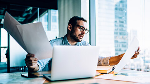 A professional deciphering a number of different printed documents