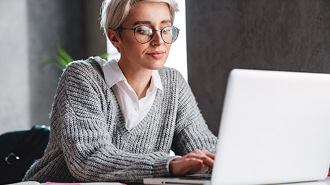 A travel agent typing up notes on a client file