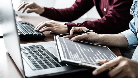 A couple of data analysts discussing data with laptops