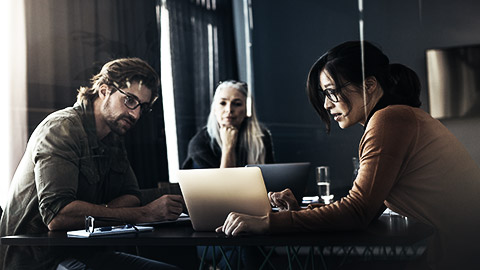 3 people discussing data in a laptop