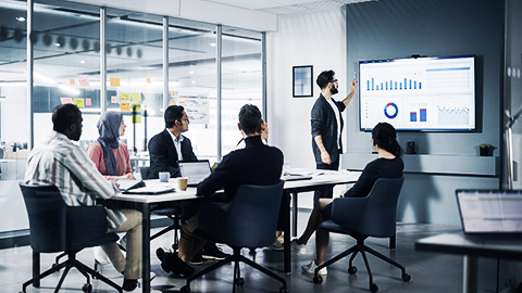 An asian man presenting data to workmates