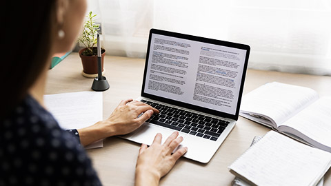 A person looking at laptop with a lots of words