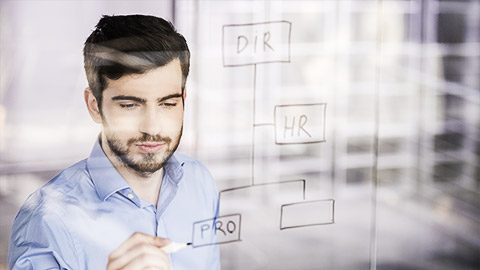 A person drawing a uml diagram on a glass board