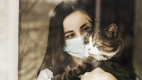 A pet owner wearing a mask to prevent zoonotic diseases