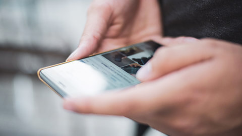 A close view of a person accessing a website with images on a phone