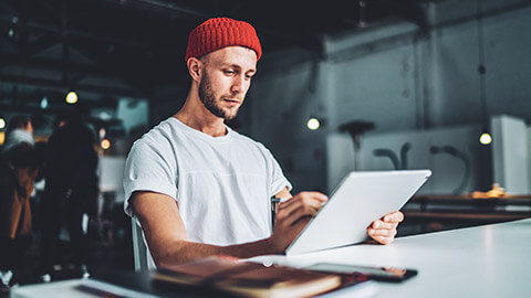 A hipster designer working on a logo on a tablet device