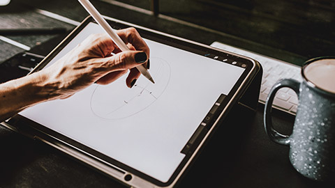 A close view of an illustrator working on a drawing on a tablet device