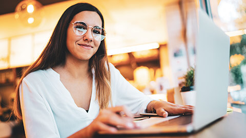 A young designer working on a laptop in a relaxed cafe