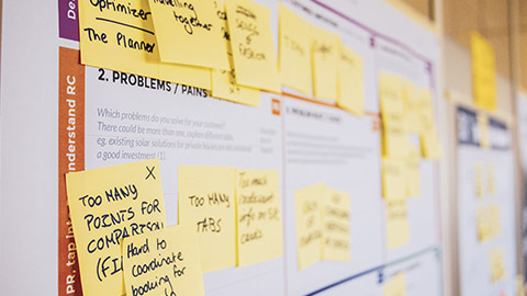 A close view of a project board with sticky notes all over it