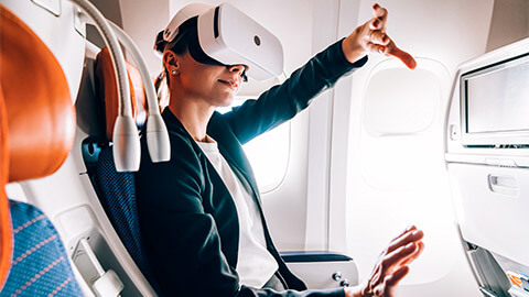 A passenger wearing VR glasses, enjoying an immersive, digital experience while on a flight