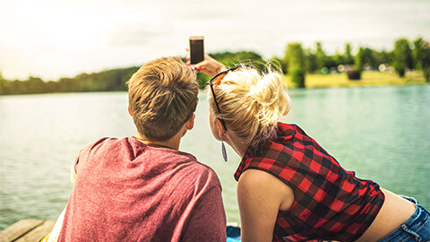 Two friends taking a selfie down by a lake