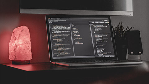 A workstation with an open laptop on it, displaying the code a UX designer has just written