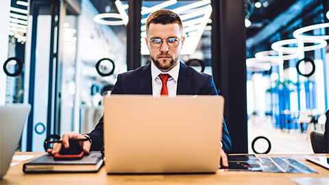 A lawyer seated at their desk, processing an email that has just come across their desk