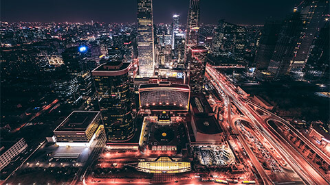 An illuminated cityscape in the early hours of the morning, before light