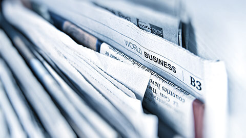 A close up of the World Business section of a large newspaper