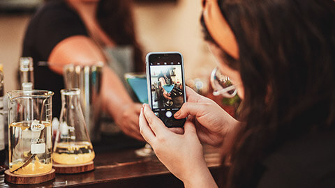 A content creator making a social media post at a bar