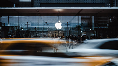 An exterior view of an Apple store in a busy city