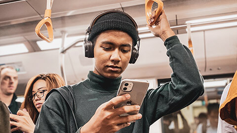 A person engaging with digital content on their phone on public transport