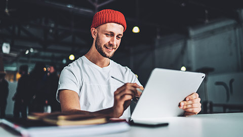 A designer working on a logo design while looking happy with himself