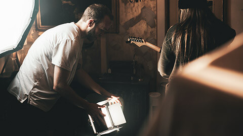 A film maker adjusting lights on a set