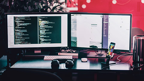 A 2 screen setup on a desk with website back end and front end visible