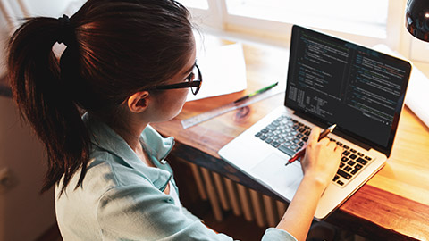 A prgrammer working on a coding project on a laptop