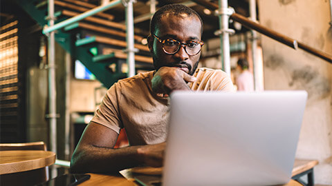 A developer seated in front of their laptop, reviewing the code quality of a new feature