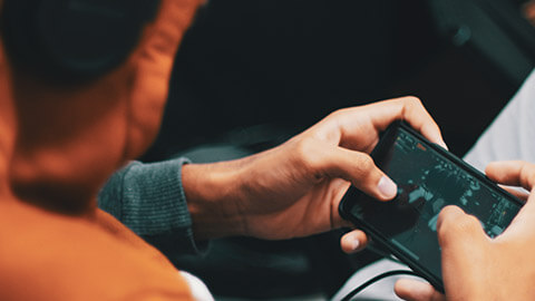 Over-the-shoulder view of a gamer using an app on a mobile device