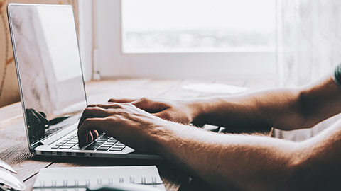 A close view of a designer working on a site on a laptop